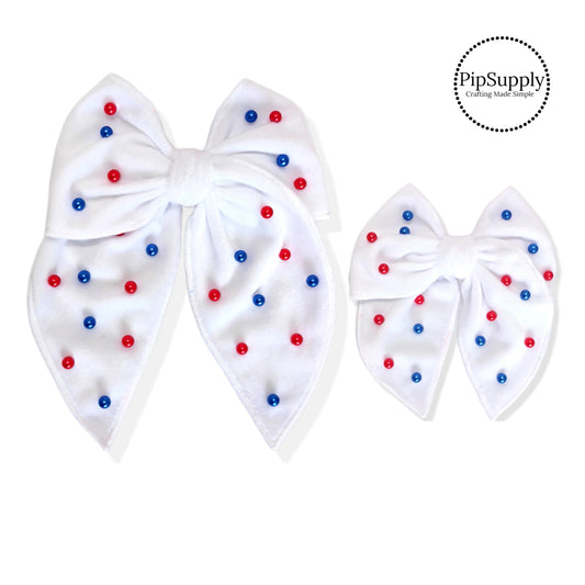 two sizes of white velvet bows with sewn red and blue pearls