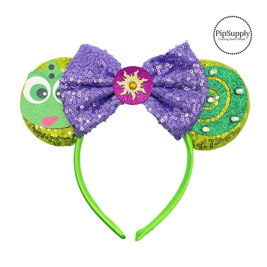 These green mouse ear headbands are a stylish hair accessory. These comfortable headbands have attached a purple glitter bow and green glitter chameleon inspired mouse ears. Along with sun embellishments. This hair accessory comes completely assembled and is great for park vacations, costumes or for everyday wear!