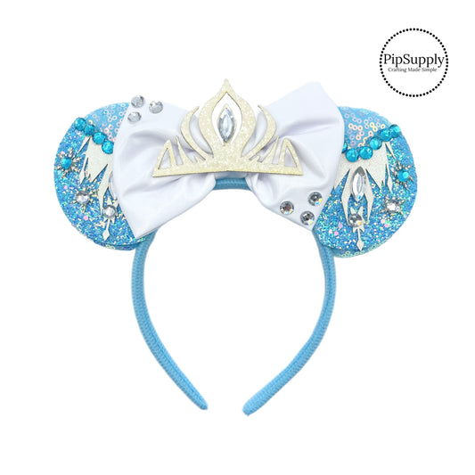 These blue mouse ear headbands are a stylish hair accessory. These comfortable headbands have attached white bow and icicles inspired glitter mouse ears. Along with a crown and rhinestone embellishment. This hair accessory comes completely assembled and is great for park vacations, costumes or for everyday wear!