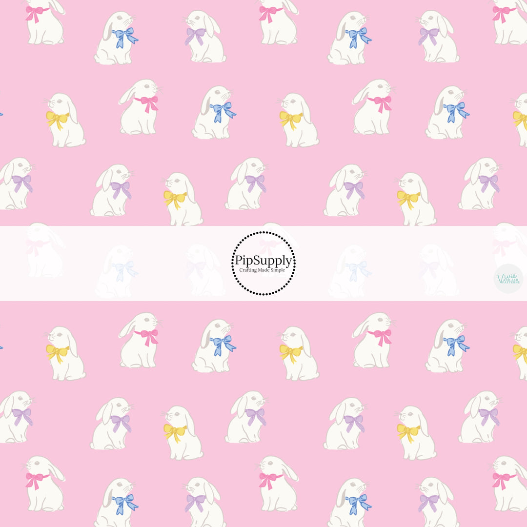 This Easter themed fabric by the yard features white bunnies with colorful bows on pink. This fun pattern fabric can be used for all your sewing and crafting needs!