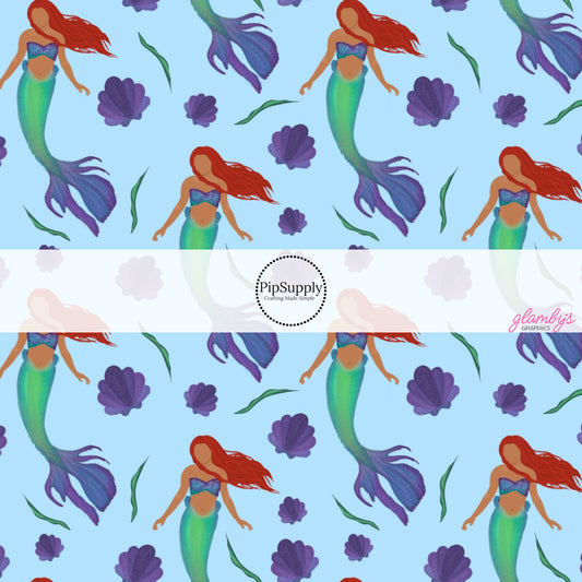 This ocean inspired fabric by the yard features the following design: red headed mermaid and sea shells on light blue. This fun themed fabric can be used for all your sewing and crafting needs!