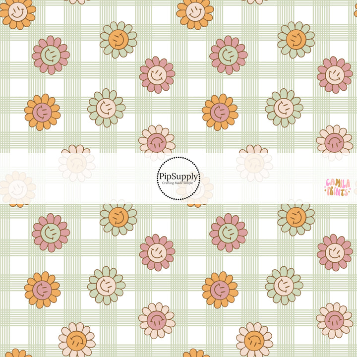 This spring fabric by the yard features smiley flowers on green and cream gingham. This fun pattern fabric can be used for all your sewing and crafting needs!