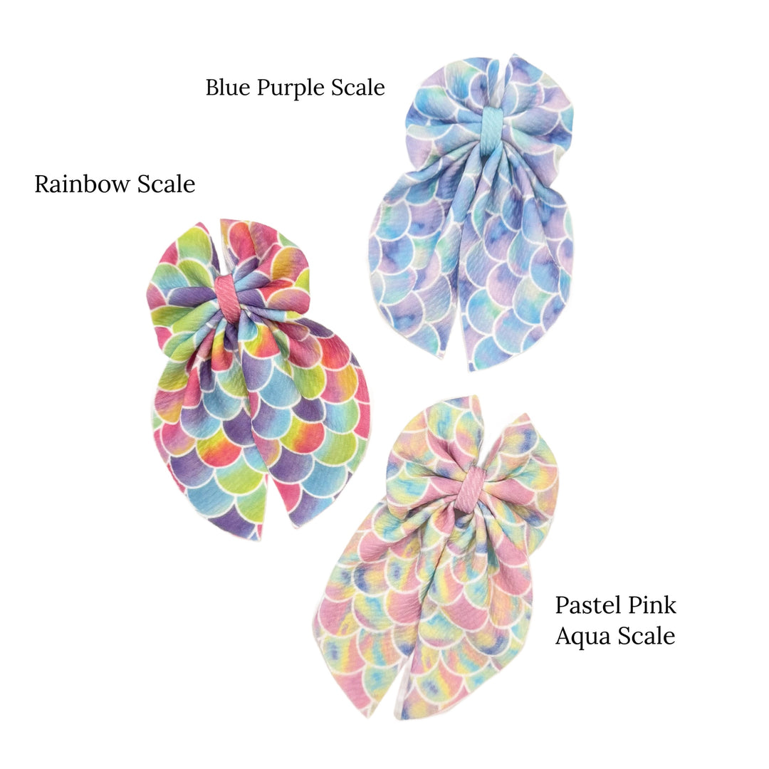 These summer mermaid themed sailor bows can be quickly cut and assembled for a trendy seasonal bow. They're ideal for easy at-home styling, individual use, or even resale. Get creative and add a splash of color to your look with these low-maintenance bows – perfect for this upcoming summer.