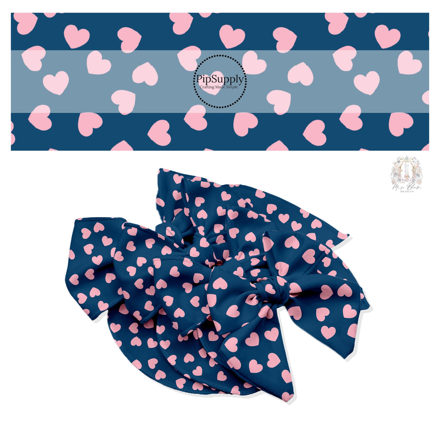 Light pink hearts in various directions on navy blue hair bow strips.