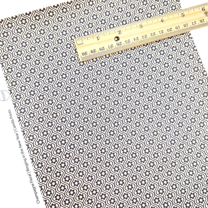 Faux leather sheet with black flowers on a champagne backgrounde