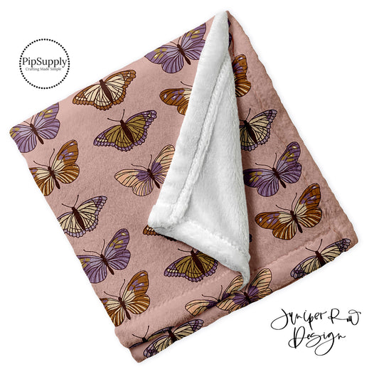 Dusty rose soft folded minky fur blanket with spring butterfly pattern.
