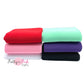 Folded solid colored neoprene fabric in red, light aqua, purple, black, light pink, and white.