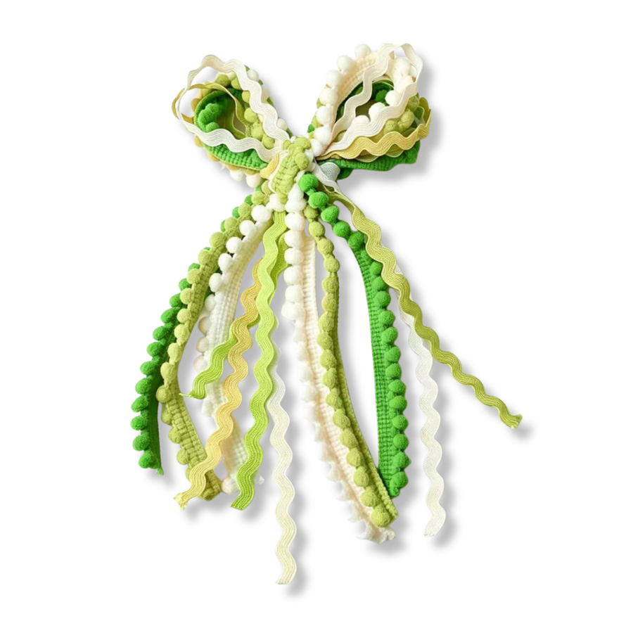 This whimsical statement bow is crafted from a mix of textured trims and ribbons in shades of lime green, moss green, cream, and soft yellow. Featuring layered ric-rac ribbon, pom-pom trim, and woven ribbon accents, the design creates a playful, dimensional look full of movement and texture. The cascading tails add a fun, boho-inspired feel, while the fresh spring color palette gives it a cheerful and charming appearance. Perfect for seasonal outfits, garden parties, St. Patrick's Day
Bow Sizing 5" x 9"
