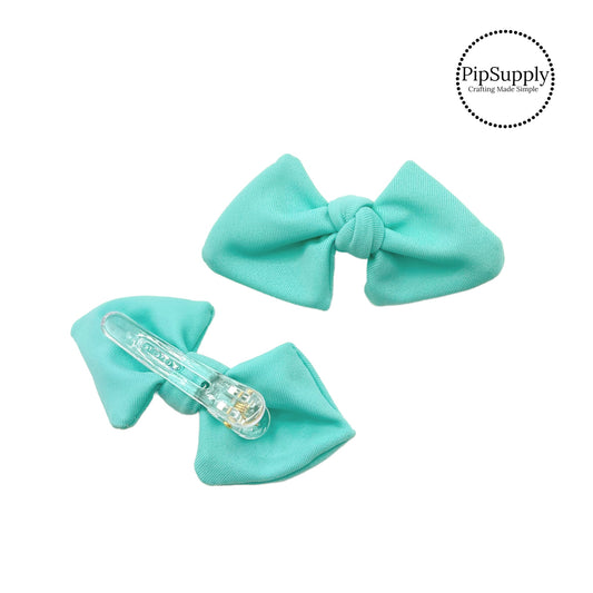 These aqua swim bows have a two layer swimsuit fabric bow with edges that are securely folded and sewn providing a professional and high quality seam. Fabric is thick high quality not coarse or stiff and the pattern is visible on all sides. Bow comes pre-tied on a clear plastic clip.