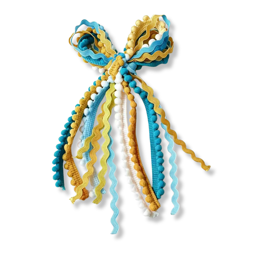 This cheerful messy bow is made from a mix of textured trims and ribbons in turquoise blue, golden yellow, white, and light blue. The bow loops are layered with coordinating ric-rac trim and pom-pom ribbon, creating a playful, dimensional look. Long flowing tails feature a combination of pom-pom trims, wavy ric-rac ribbons, and textured ribbon strands that cascade from the center knot. 
Bow Sizing 5" x 9"