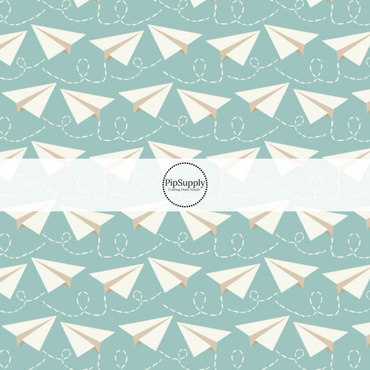 Light aqua fabric by the yard with white paper airplanes.
