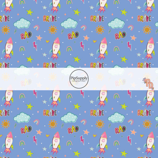 Powder Blue fabric by the yard with stars, space ships, rainbows, and other sky an outer space designs.
