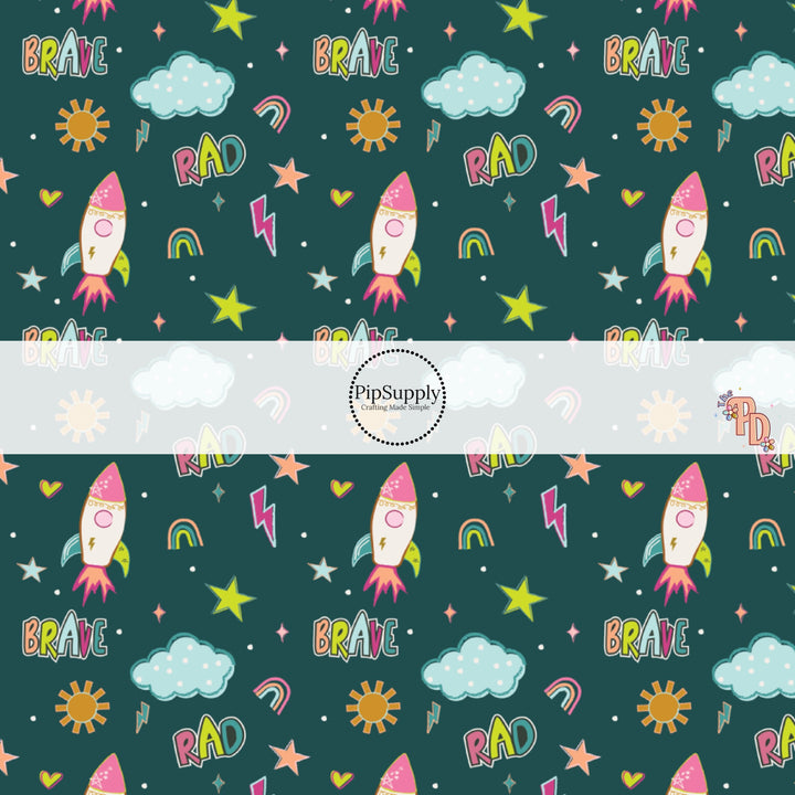 Teal fabric by the yard with stars, space ships, rainbows, and other sky an outer space designs.