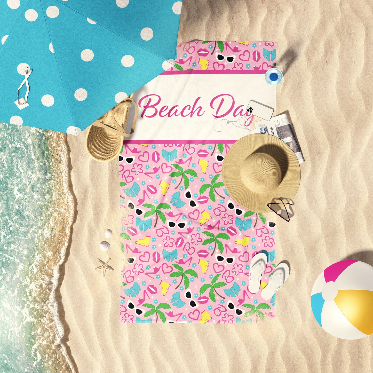Hot pink and pink summer dressup print beach towel laid out by the water at the beach.