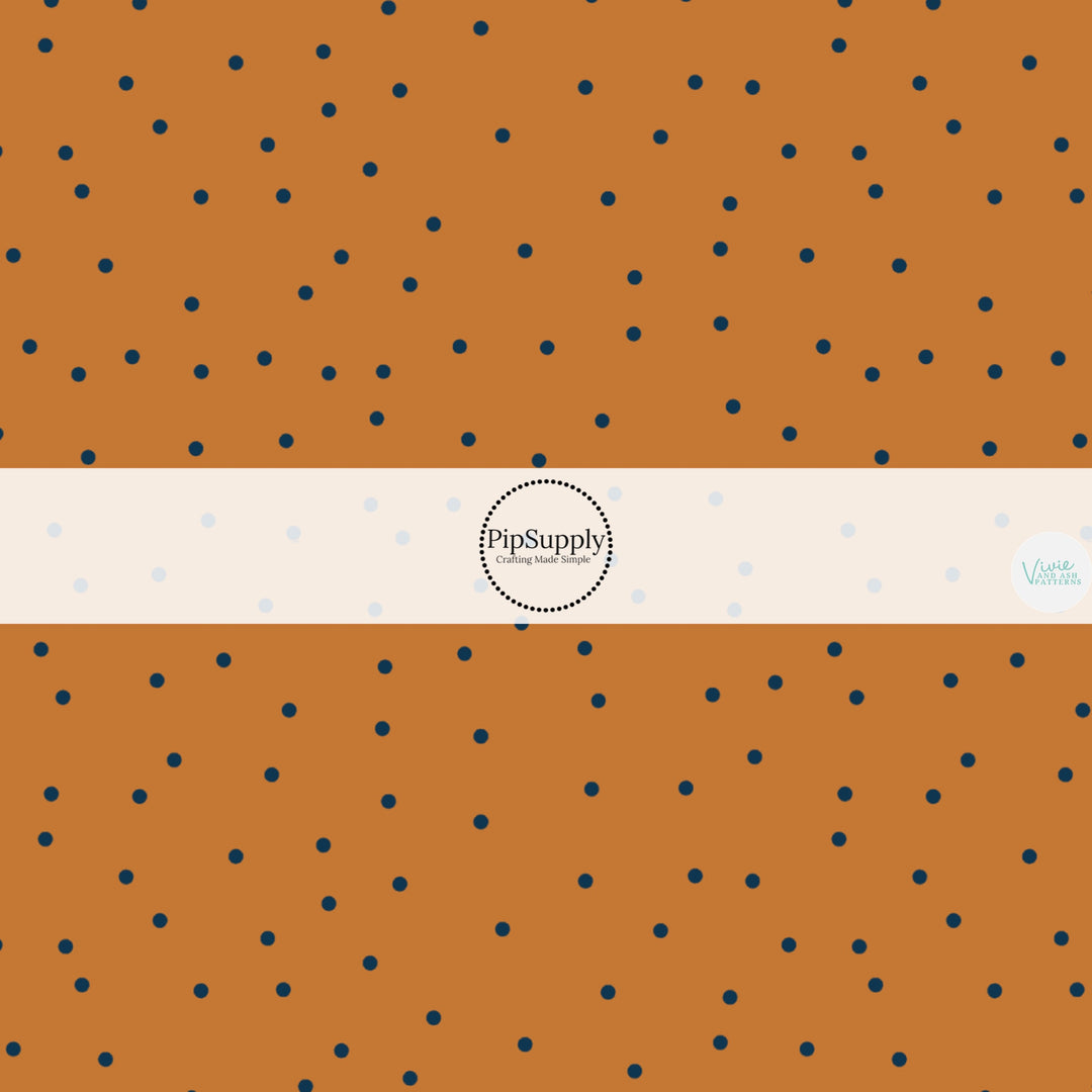 Pumpkin orange colored fabric by the yard with scattered black dots.