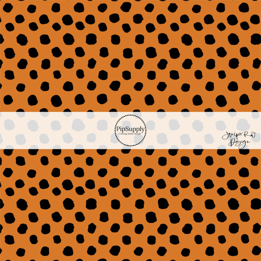 Orange fabric by the yard with scattered black speckled dots.