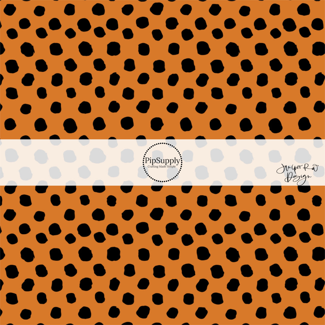 Orange fabric by the yard with scattered black speckled dots.