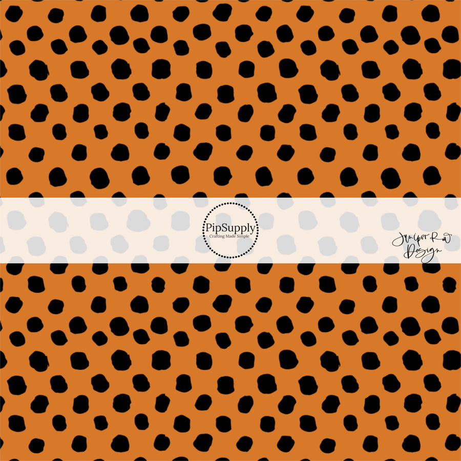 Orange fabric by the yard with scattered black speckled dots.