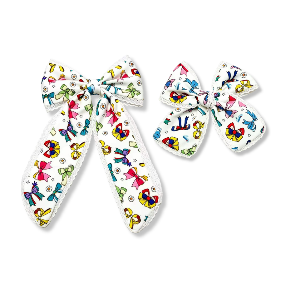 These charming bows feature a white ribbon printed with colorful bow designs in vibrant shades of pink, blue, yellow, green, purple, and red. Delicate white lace trim adds a soft, elegant finish, while the playful bow-themed pattern creates a cheerful and whimsical look. Available in both a larger statement bow and a smaller matching style, these bows are perfect for adding a fun pop of color to any outfit.
you choose size 
Small 5" X 6"
Large 5.5" X 9.5"