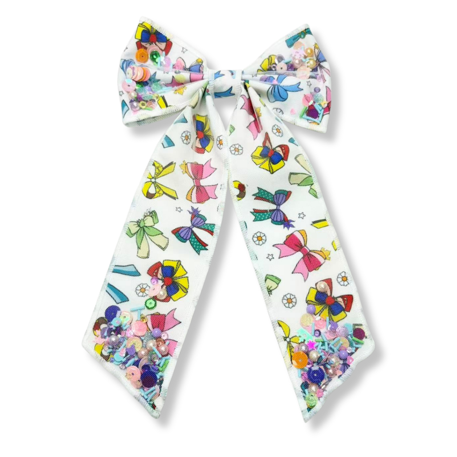 This eye-catching **shaker bow** features a white ribbon printed with colorful bow designs in vibrant shades of pink, blue, yellow, green, and purple. The shaker sections are filled with pastel sequins, beads, and confetti-like embellishments that add sparkle, texture, and movement.
Bow Sizing 5" x 8.5"