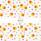 White fabric by the yard with scattered candy corn, dots, and stars.