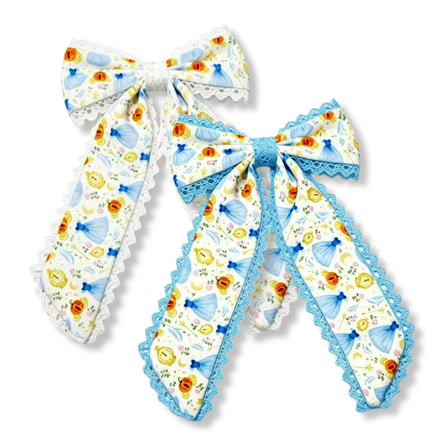 These elegant princess-inspired bows feature a whimsical print on a white background adorned with light blue gowns, pumpkins, enchanted clocks, glass slippers, and delicate fairytale details. The bows are finished with decorative lace trim that adds texture and charm.One style accented with classic white lace and the other with coordinating light blue lace. 
you choose white of blue lace trim
Large 5.5" X 9.5"