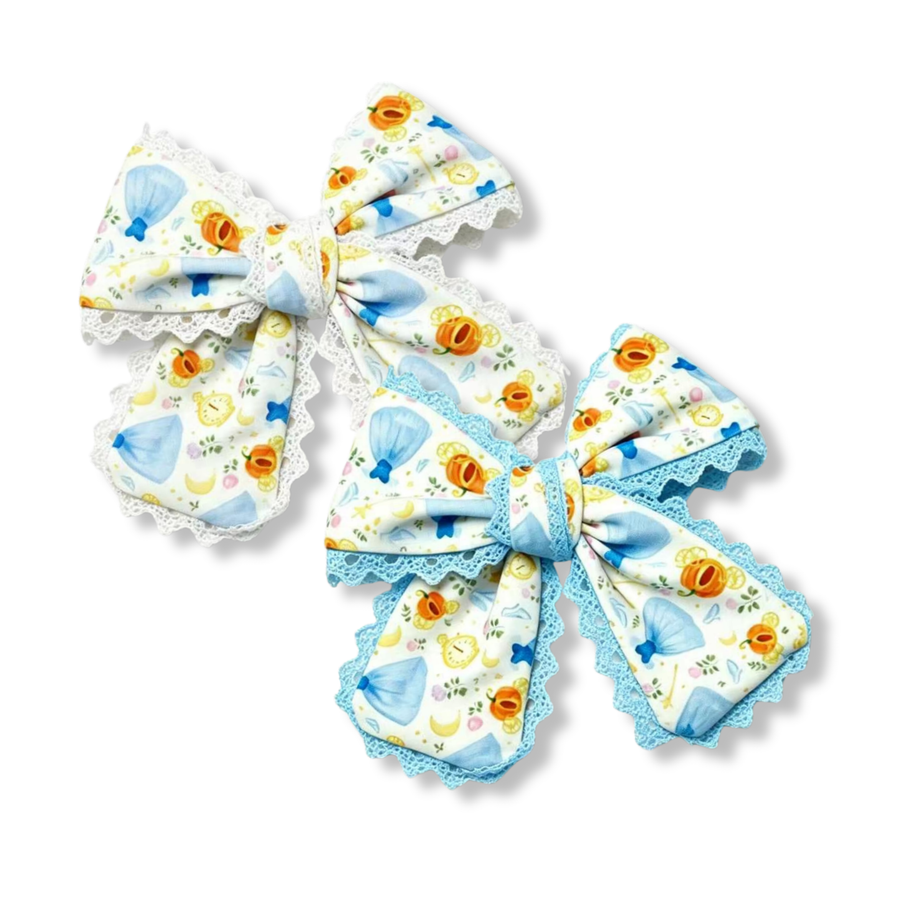 These charming princess-inspired bows feature a whimsical fairytale print on a white background with light blue gowns, magical pumpkins, enchanted clocks, crescent moons, and delicate floral accents. The bows are accented with decorative lace trim for added texture and elegance.One style finished with classic white lace and the other with coordinating light blue lace. 
you choose white or blue lace trim
Small 5" X 6"