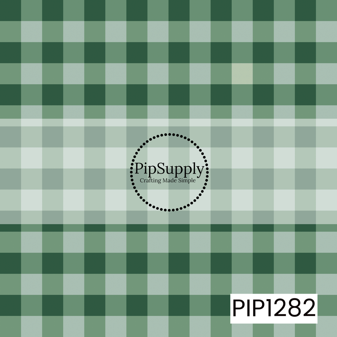 A timeless gingham pattern featuring rich forest green and soft sage checks layered over a creamy white background. The mix of deep and muted greens gives this classic plaid a warm, cozy feel.
