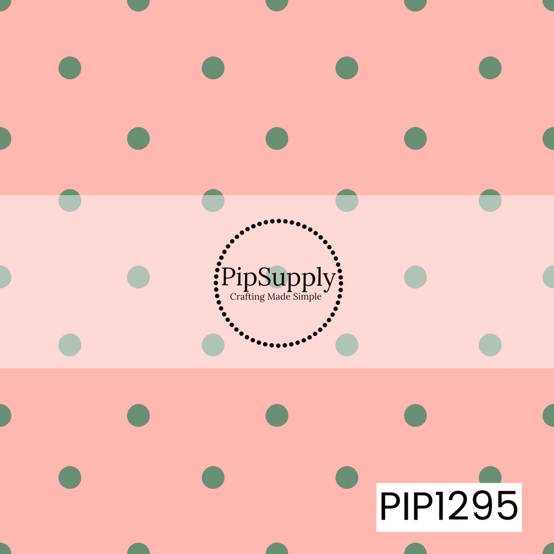 A playful polka dot pattern featuring muted sage green dots evenly scattered across a warm blush pink background. The soft red and green inspired palette gives it a subtle festive feel.
