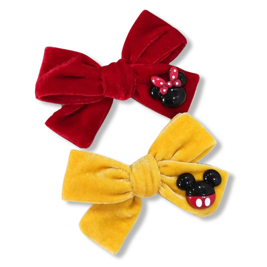 **Red Velvet Bow**
This elegant red velvet bow features a rich, soft texture with beautifully structured loops and tails. Attached to one side is a glossy mouse-inspired embellishment with a classic red polka-dot bow. 
**Yellow Velvet Bow**
This cheerful yellow velvet bow showcases a plush, velvety texture and a classic bow silhouette with neatly folded loops and tails. A glossy mouse-inspired embellishment is attached to one side, featuring the character’s signature black ears 
4.5" x 4.5"