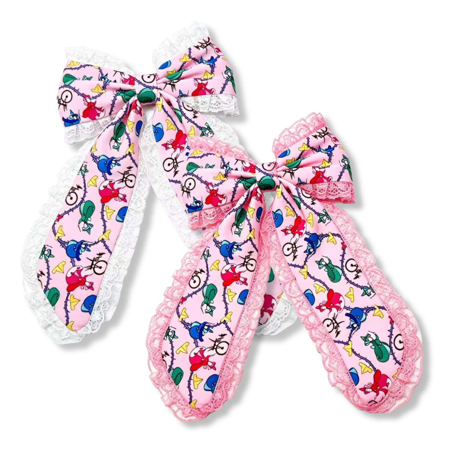 These elegant long tail boutique bows feature a whimsical pink character print accented with delicate lace trim. Available with either white or pink ruffled lace edging, the oversized tails showcase colorful character silhouettes, swirls, and playful details on a soft pastel pink background. The layered construction adds volume and charm, creating a sweet vintage-inspired accessory perfect for themed outfits, special occasions, and everyday magical style.
Large 5.5" X 9.5"