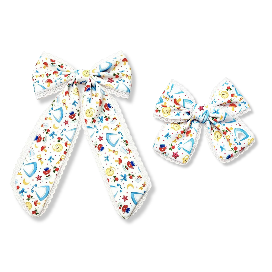 A charming fairytale-inspired bow featuring glass slippers, clocks, bows, stars, and whimsical storybook details on a white background. Delicate white lace trim accents the edges, adding a sweet vintage touch to this magical and elegant design. 
two sizes
Large 5.5" X 9.5"
Small 5" X 6"