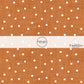 Orange faux linen fabric by the yard with white scattered dots.