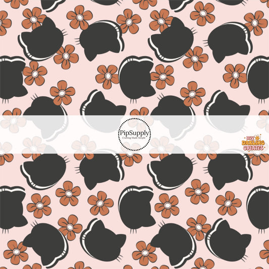 Light pink fabric by the yard with black cat silhouettes and rust orange flowers.
