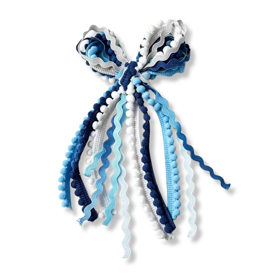 A playful messy bow crafted from an assortment of ric rac ribbons, pom-pom trim, and textured woven ribbons in shades of light blue, navy, and white. The layered ribbons feature wavy edges, soft pom-pom accents, and varied textures that create beautiful movement, dimension, and a whimsical handcrafted look. 
Bow Sizing 5" x 9"