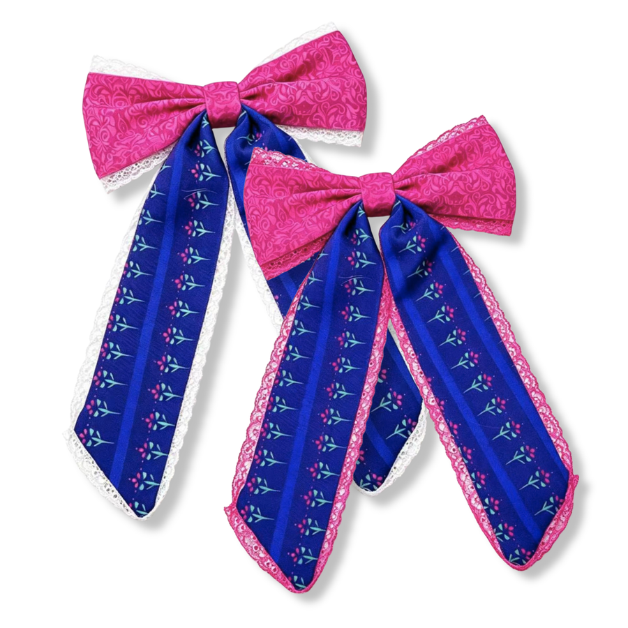 These elegant long-tail bows feature vibrant berry pink and royal blue ribbons adorned with delicate floral accents. each bow is outlined in either matching pink or white lace. you choose. 
Large 5.5" X 9.5"