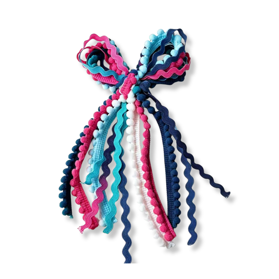A playful boutique bow crafted from layered ric rac trim and pom-pom ribbon in vibrant shades of pink, aqua, navy, and white. 
Bow Sizing 5" x 9"
