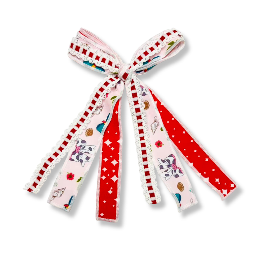 This three-ribbon tie bow combines playful coastal-inspired prints with bold pops of red. One ribbon features a soft pink background adorned with seashells, bows, flowers, and whimsical beach-themed accents. A second ribbon showcases a vibrant red print with scattered white star-like shapes for a bright, cheerful contrast. The third ribbon is a decorative red-and-white woven trim finished with delicate white scalloped lace edging, adding texture and dimension. Bow Sizing 4" x 8"
