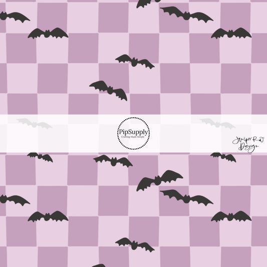 Black scattered bats on purple checkered fabric by the yard.