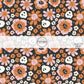 White skeletons and pink and orange floral prints on black fabric by the yard.