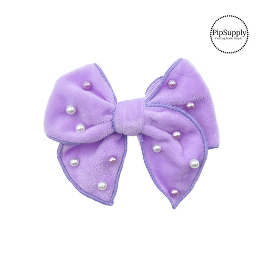 These lavender velvet pre-cut bow strips are ready to package and resell to your customers no sewing or measuring necessary! These hair bows come with a alligator clip already attached. The pearls are hand stitched on the purple velvet hair bow.
