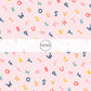 Light pink fabric by the yard with multi-colored scattered alphabet letters.