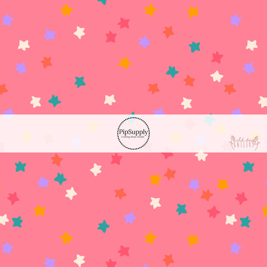 Pink fabric by the yard with white, pink, yellow, pink, and purple scattered stars.