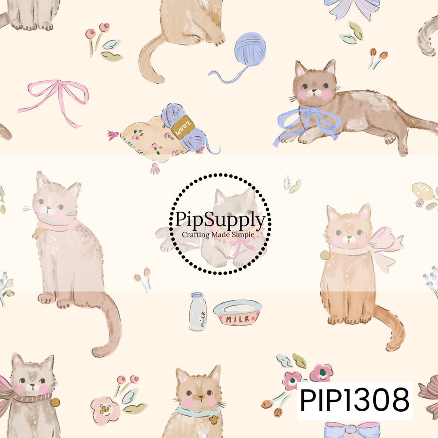 A sweet hand-painted cat print featuring playful kitties dressed in bows and collars, paired with yarn, floral accents, milk, and other cozy details. Soft shades of blush pink, dusty blue, warm brown, and cream give it a charming vintage cottage feel.
