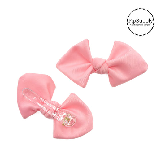 These peachy pink swim bows have a two layer swimsuit fabric bow with edges that are securely folded and sewn providing a professional and high quality seam. Fabric is thick high quality not coarse or stiff and the pattern is visible on all sides. Bow comes pre-tied on a clear plastic clip.