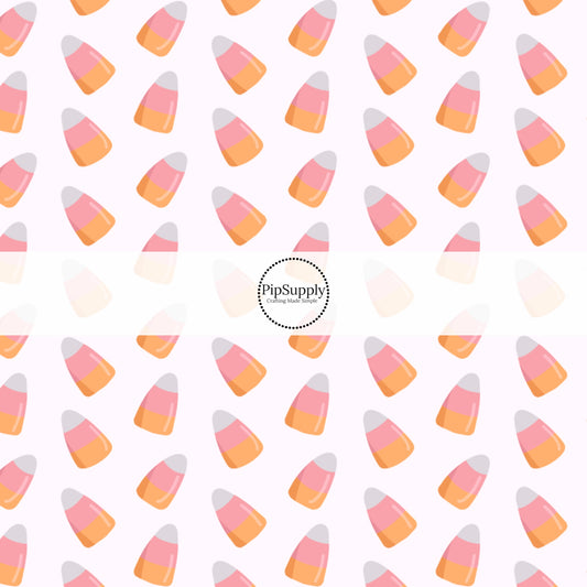 Bone white fabric by the yard with scattered pink, white, and orange candy corn.