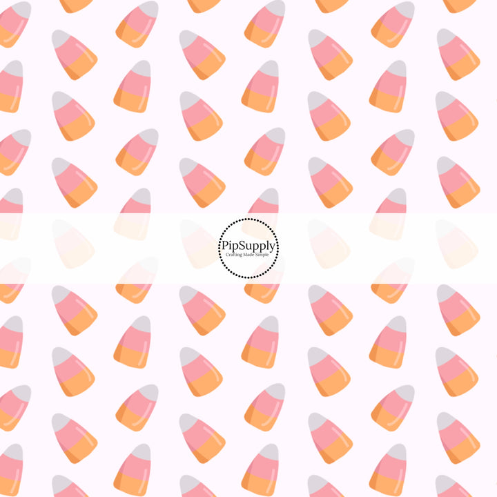 Bone white fabric by the yard with scattered pink, white, and orange candy corn.