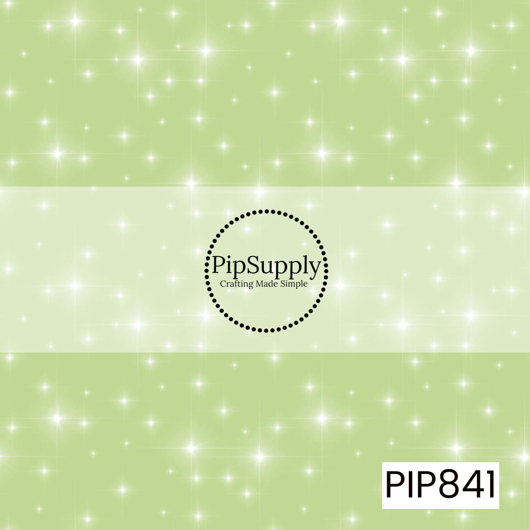Soft pastel green background featuring a scattered pattern of glowing white sparkles and twinkling starbursts in varying sizes. The delicate light effects create a shimmering, magical appearance across the design, while the simple color palette gives it a clean, airy, and enchanting aesthetic. Perfect as a versatile coordinate, the pattern adds a subtle touch of sparkle and whimsy.
