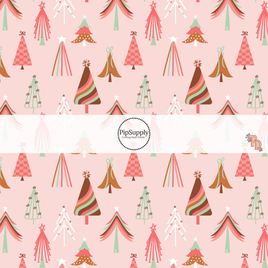 Light pink fabric by the yard with multi-colored Christmas trees.