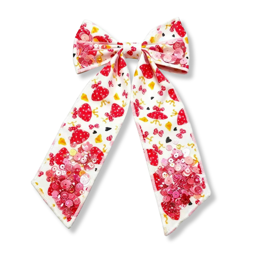 This elegant boutique bow features a white ribbon printed with red polka-dot dresses, bows, hearts, and coordinating character-inspired accents. Sparkling sequin clusters embellish the loops and tails, adding dimension and shine. Finished with long, classic tails and a matching center wrap, this bow combines playful charm with a touch of sparkle.
Bow Sizing 5" x 8.5"